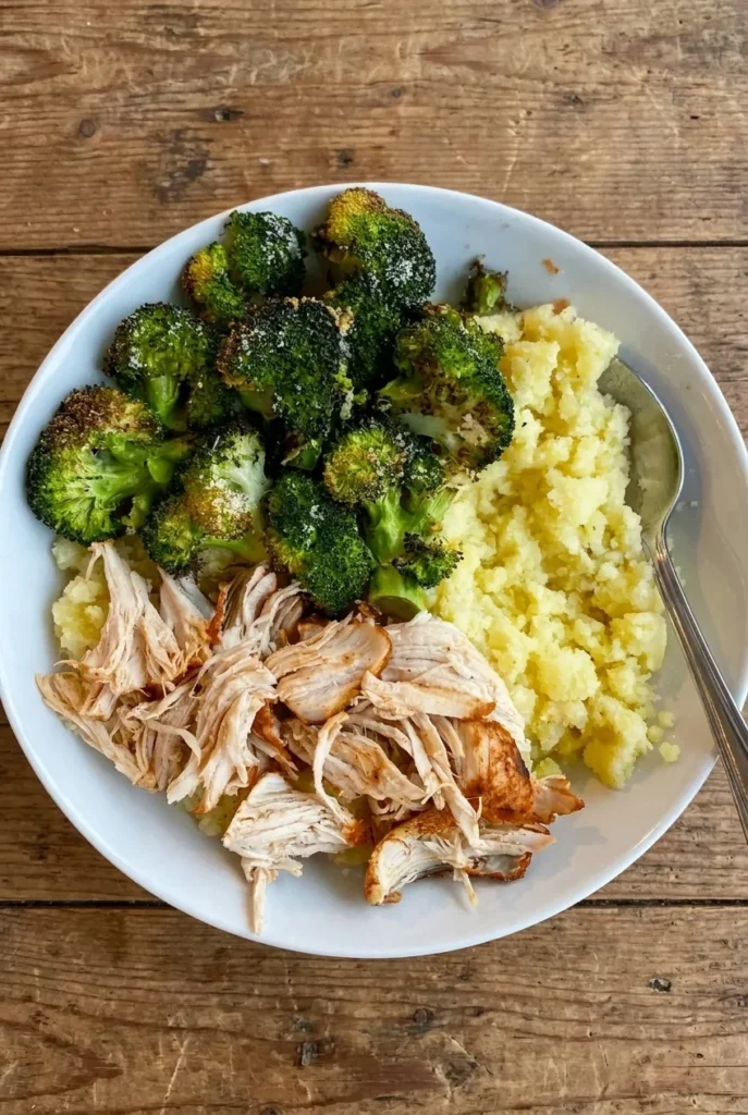 plated meal with pulled chicken, creamy mashed potatoes and crispy parmesan broccoli