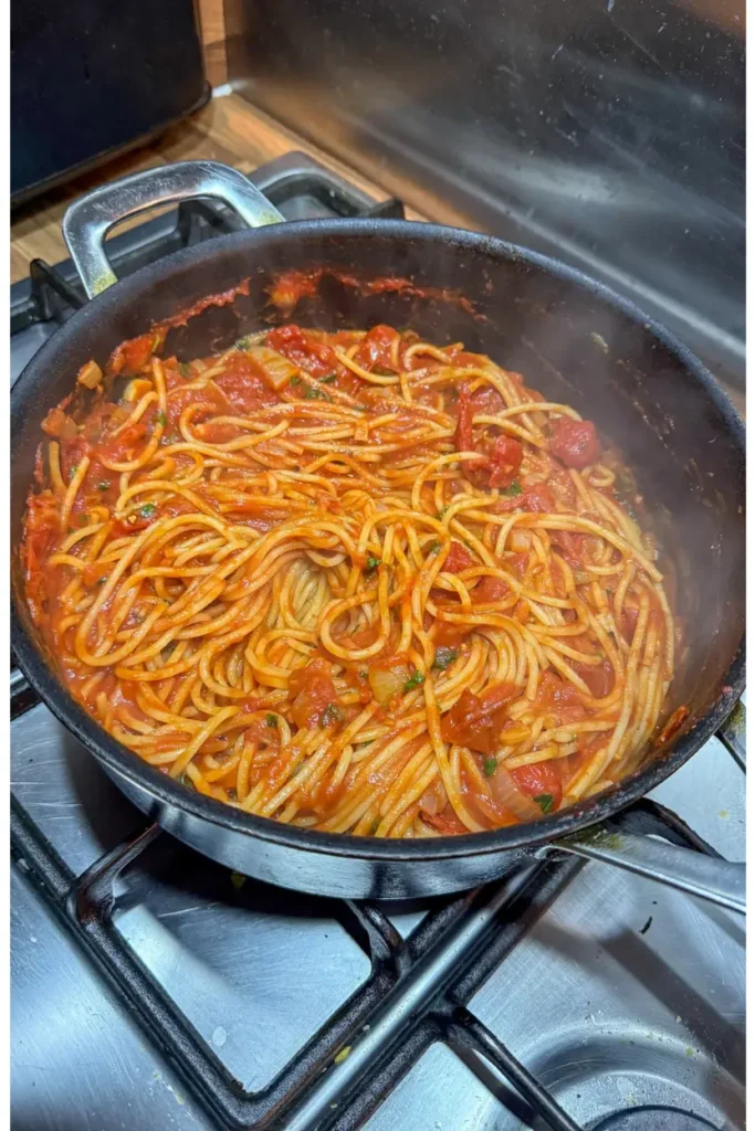 tossing the pasta and sauce