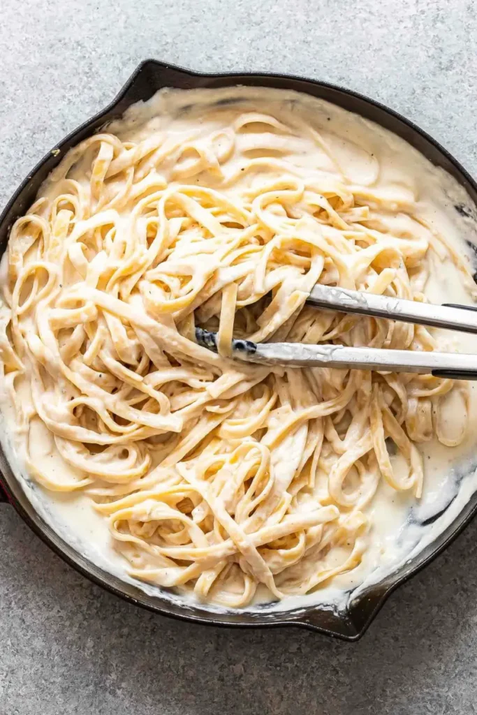 Pasta fully coated in Alfredo sauce